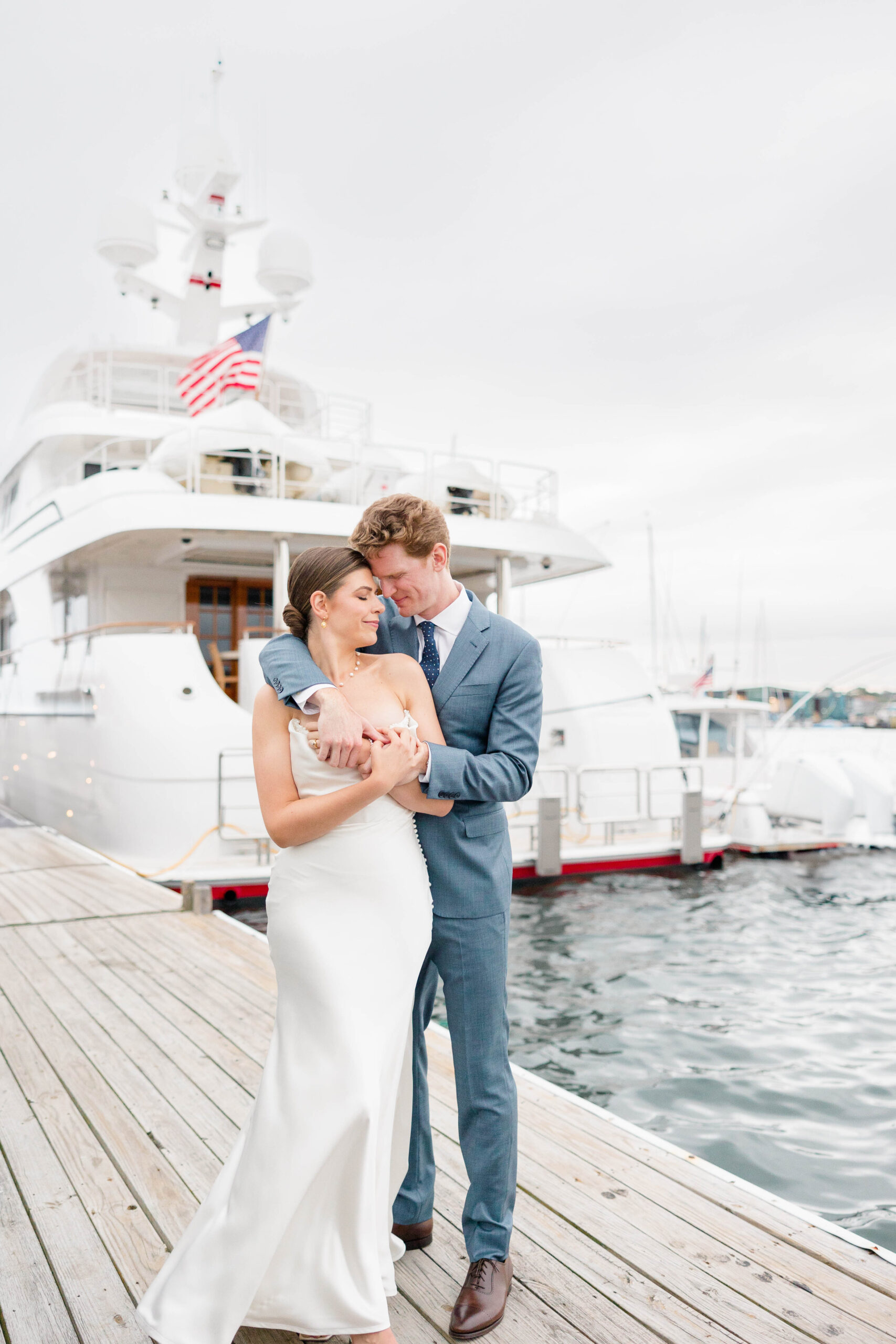 Newport RI Wedding Photographer and Videographer | Serving CT, RI, Massachusetts, and Surrounding New England Areas | Bride and groom embracing on the port dock