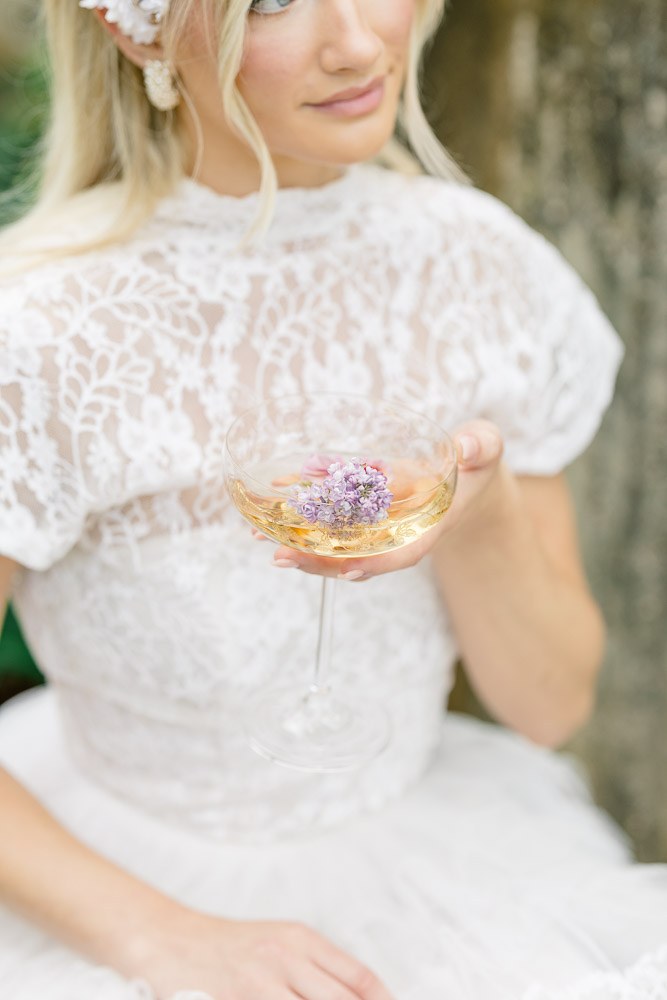 Newport Videographer and Wedding Photographer | Serving CT, RI, and New England Areas | Bride holding a champagne glass with a purple flower