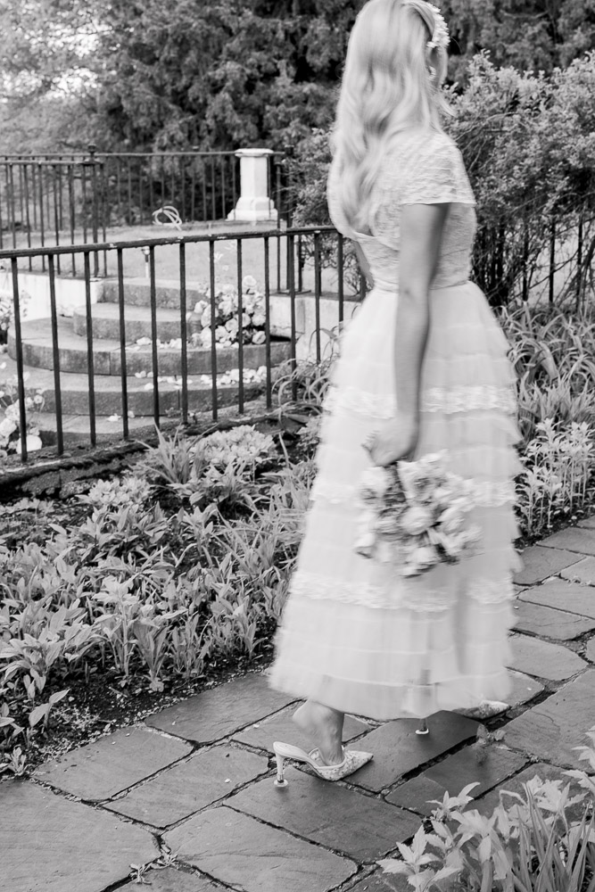 Connecticut Wedding Photographer and Wedding Videographer | Serving Newport, RI, and New England Areas | Bride holding a bouquet while strolling in the garden