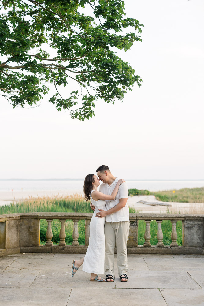 Couples Photographer CT and Wedding Videographer | Serving Newport, RI, and New England Areas | Engaged couple embracing on the terrace at Eolia Mansion