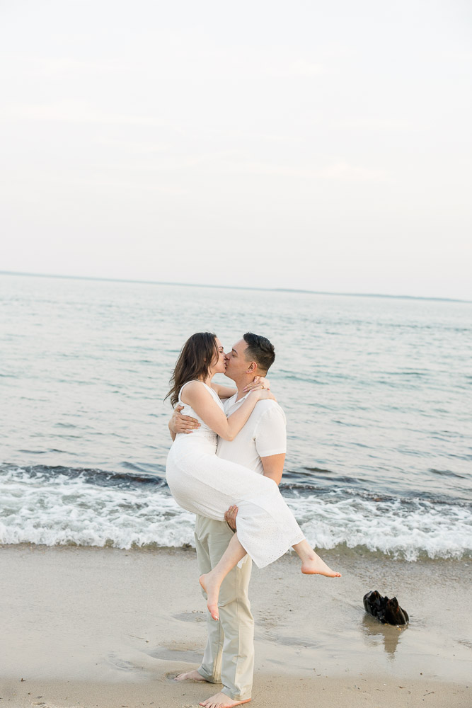 Engagement Session Newport RI and Wedding Videographer | Serving CT, RI, and New England Areas | Man picks up fiancee and kisses her by the beach