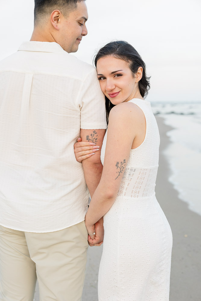 Engagement Session Newport RI and Wedding Videographer | Serving CT, RI, and New England Areas | Woman leaning on her fiance's arm by the beach