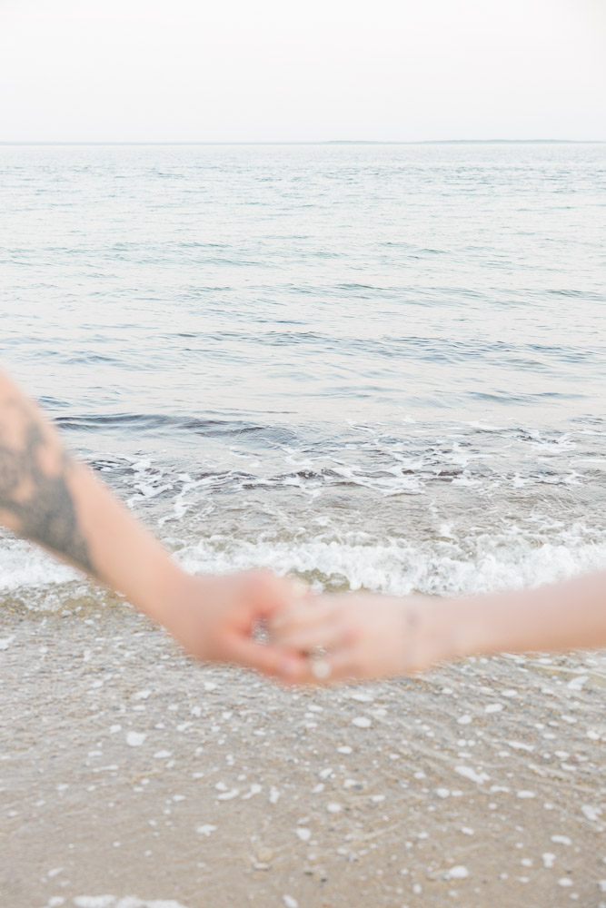 Engagement Session Newport RI and Wedding Videographer | Serving CT, RI, and New England Areas | Close up shot of engaged couple holding hands by the beach