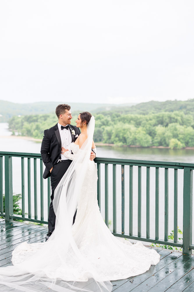 CT Wedding Photographer and Wedding Videographer | Serving Newport, RI, and New England Areas | Bride and groom embracing on the deck of a mansion