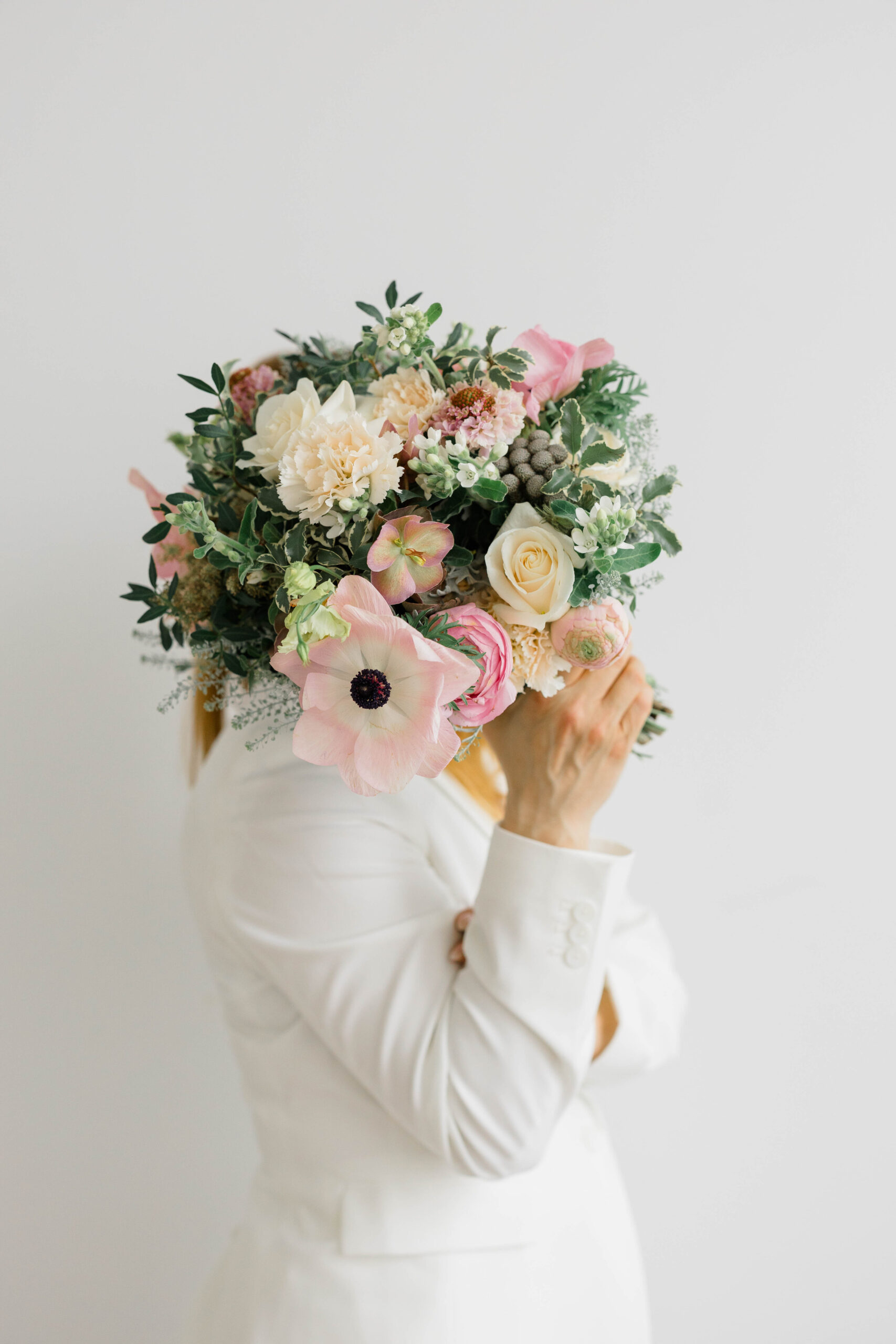 Newport Wedding Photographer and Videographer | Serving CT, RI, Massachusetts, and Surrounding New England Areas | Branding photo of a woman holding a bouquet of pink florals