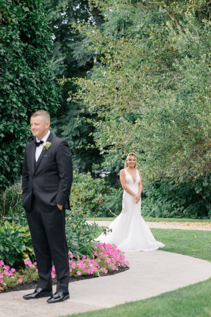 Bride approaching groom for a first look at an elegant estate wedding