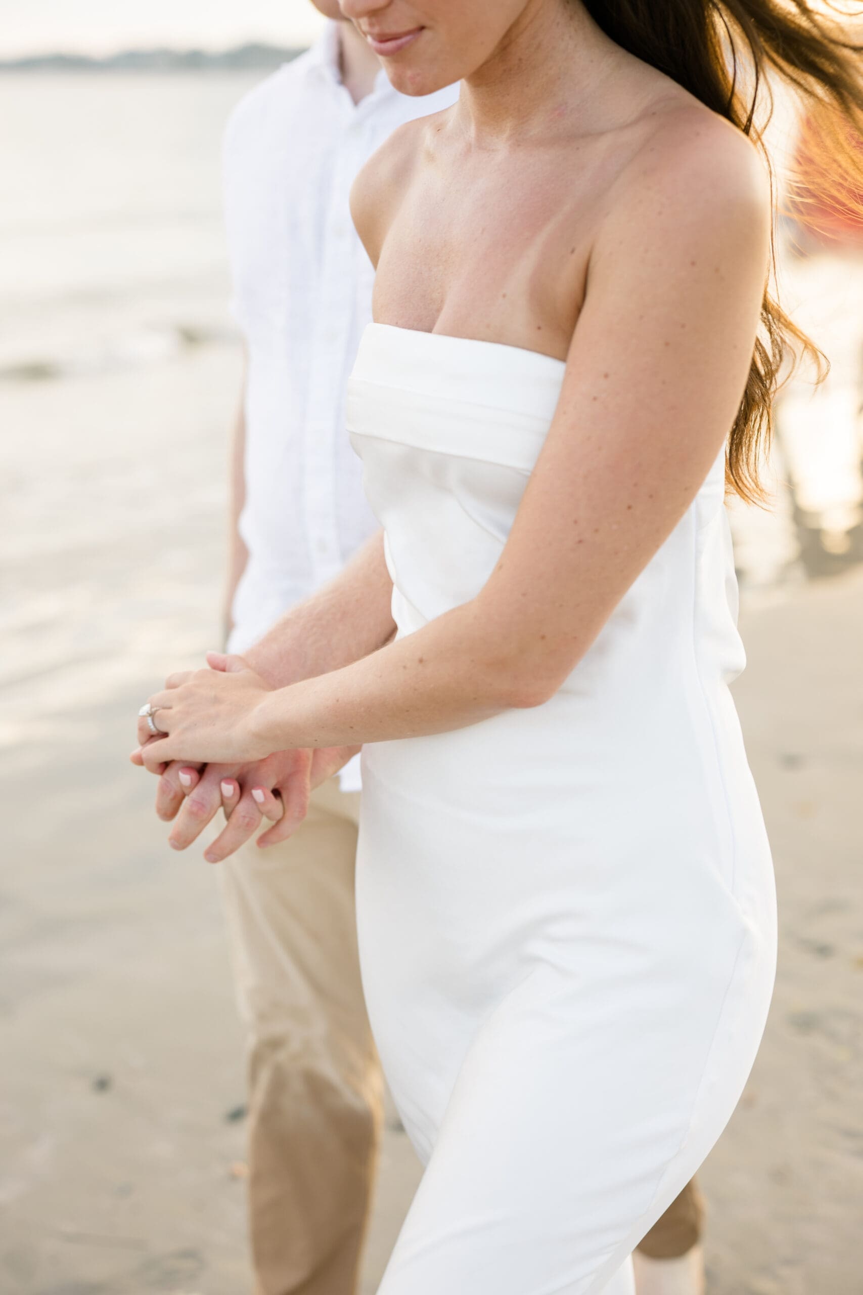 Couple holding hands during a Newport beach engagement session.