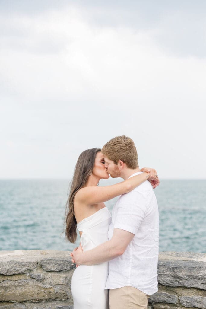 Couple embracing by the ocean during a Newport engagement session along the Rhode Island coast.