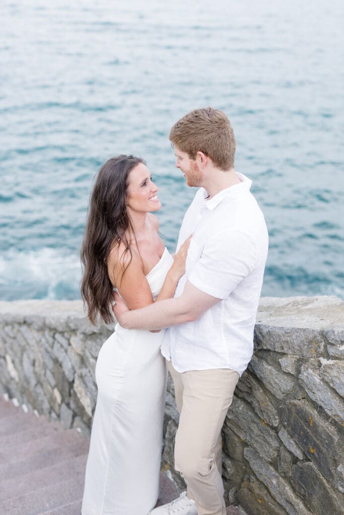 Couple embracing by the ocean during a Newport engagement session along the Rhode Island coastline.