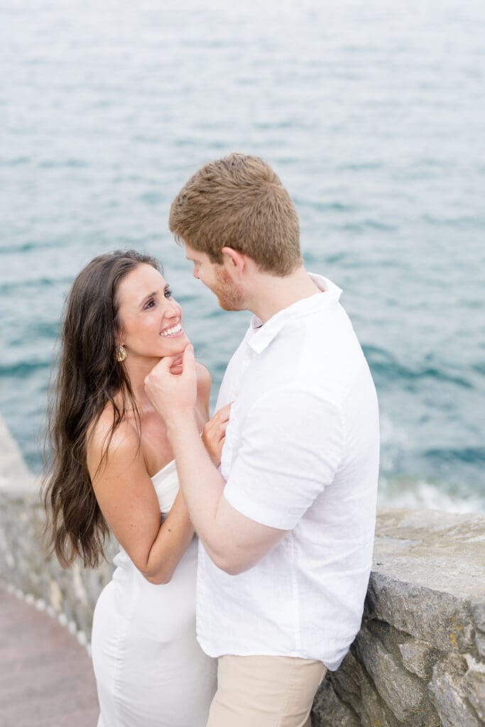 Couple sharing a quiet moment by the ocean during a Newport engagement session along the Rhode Island coast.